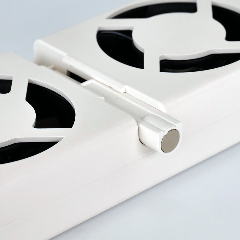 Close-up of a white metal grate with circular cutouts on a light gray background